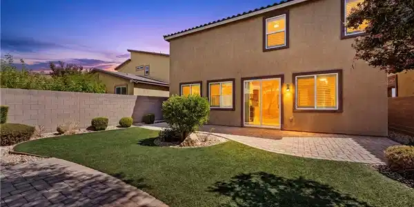 Image 3: A private backyard oasis features lush artificial