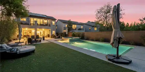 Image 2: A private backyard oasis features a shimmering poo