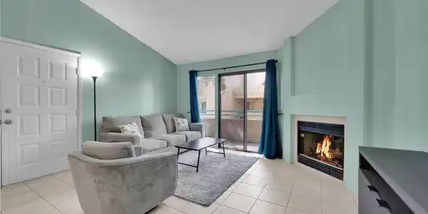 Image 2: Vaulted ceilings and a wood-burning fireplace crea