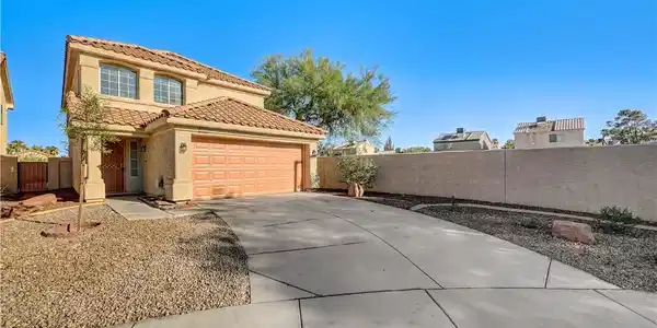 Image 2: A curved concrete driveway leads past desert lands