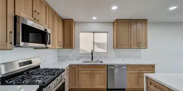 Image 3: Modern cabinetry and stone countertops elevate thi