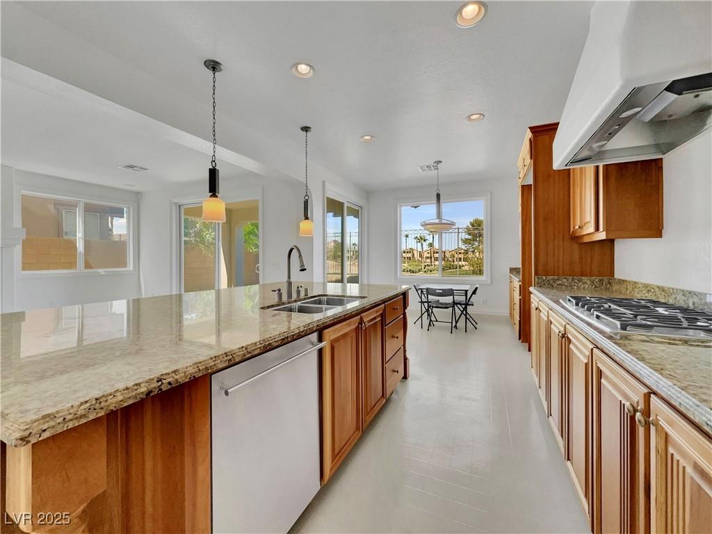 Image 3: Kitchen with brown cabinetry, appliances with stai