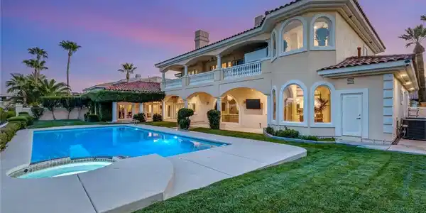 Image 4: An inviting backyard features a sparkling swimming