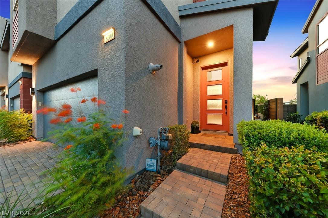 Image 3: A vibrant orange door welcomes you to this contemp