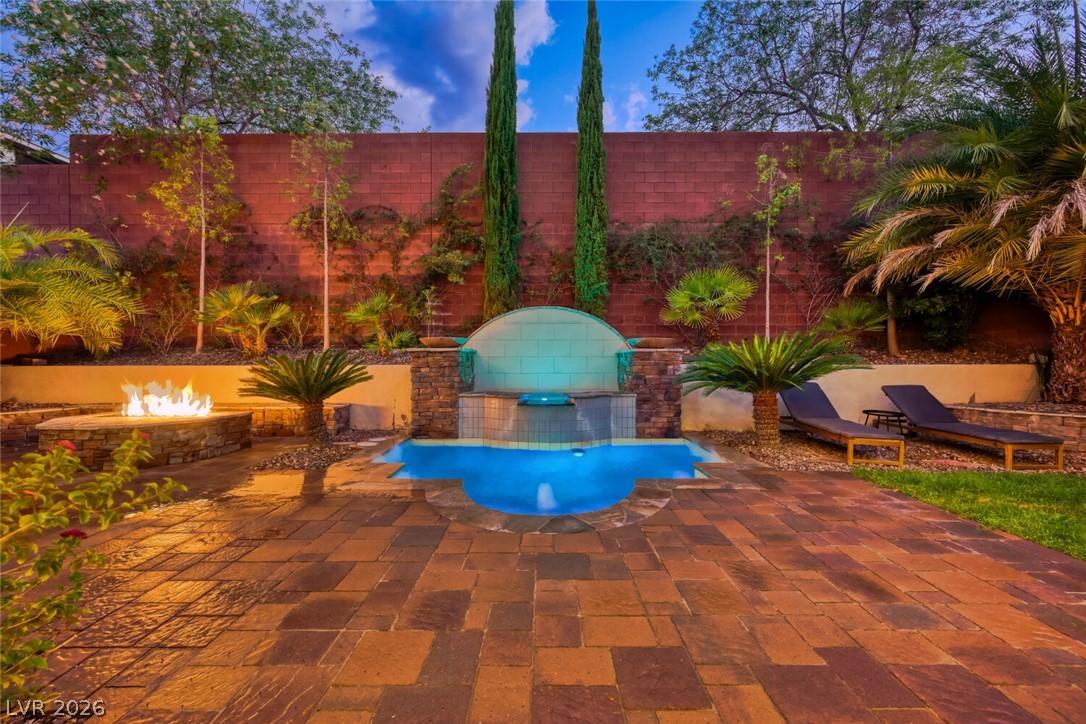 Image 4: An inviting backyard oasis offers a serene pool, a