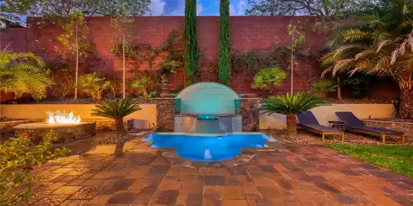 Image 4: An inviting backyard oasis offers a serene pool, a