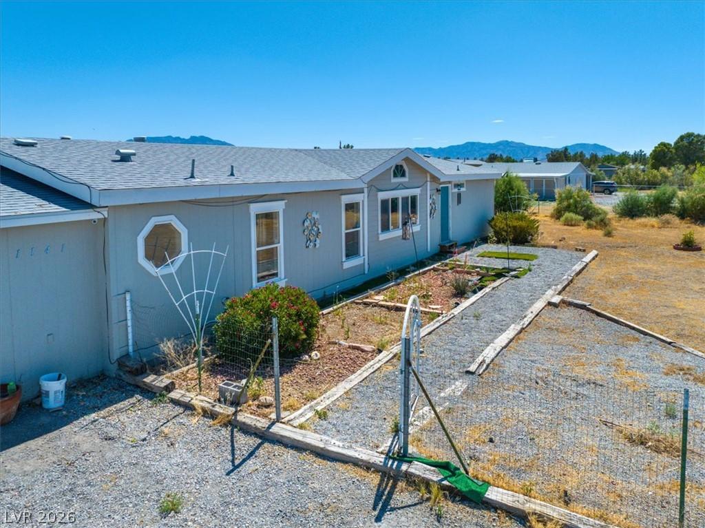 Image 4: A modest light blue residence featuring a landscap