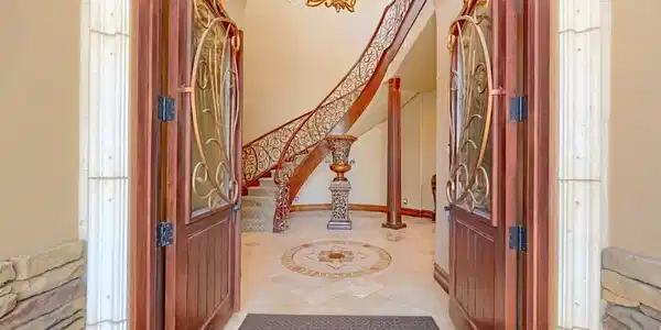 Image 4: Double doors open to reveal a sweeping staircase,