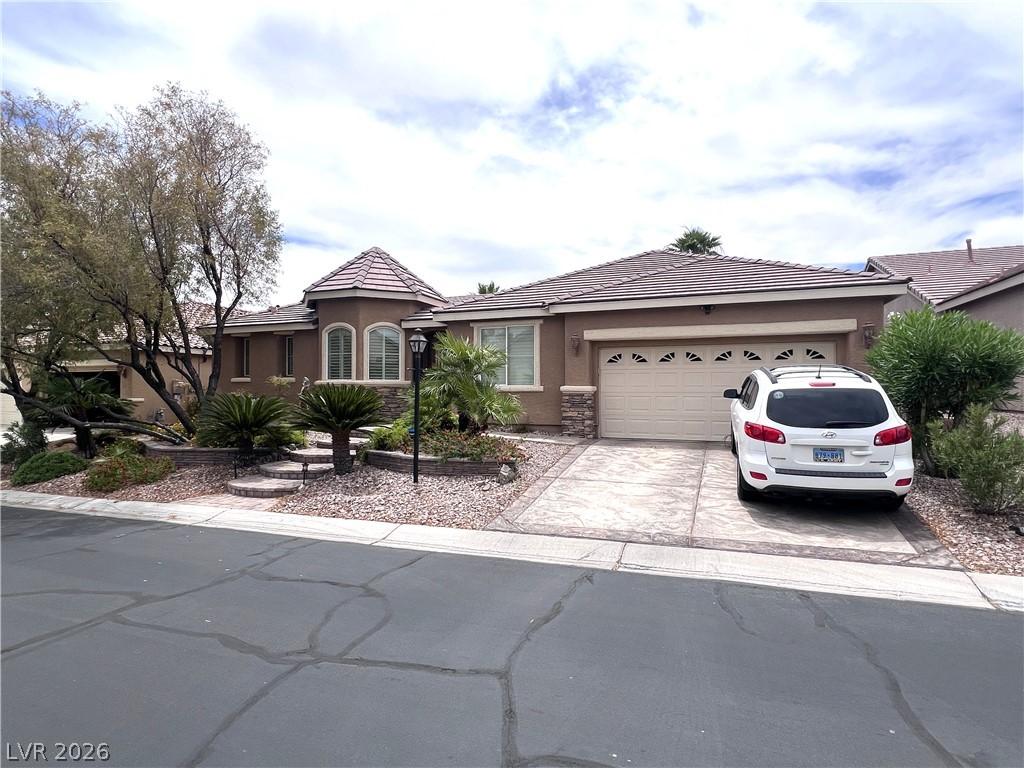 Image 2: A well-manicured yard and inviting driveway enhanc