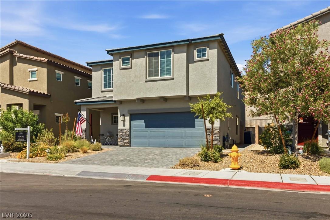 Image 4: A contemporary stucco home boasts a large two-car