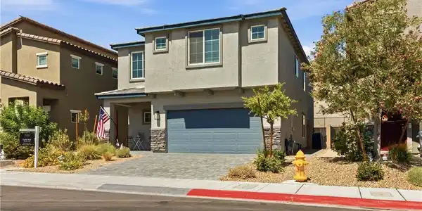 Image 4: A contemporary stucco home boasts a large two-car