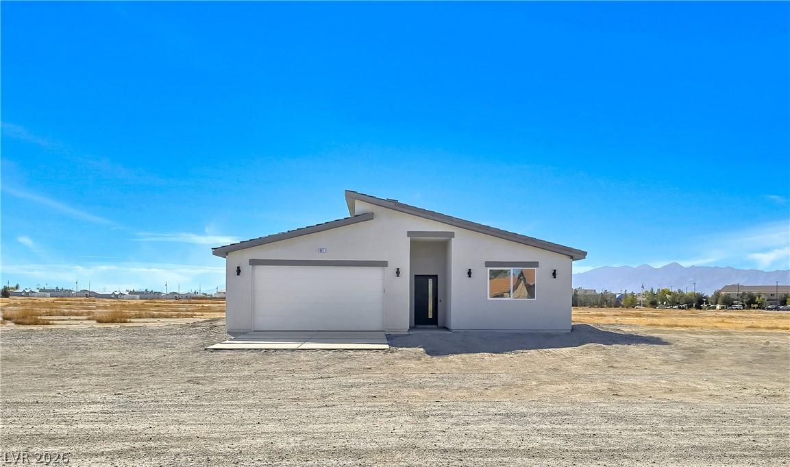 Image 2: Front view of property featuring stucco siding and