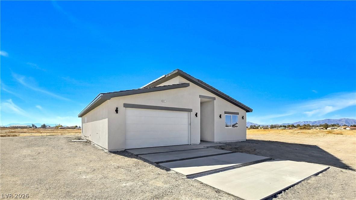 Image 3: View of side of home with stucco siding, concrete