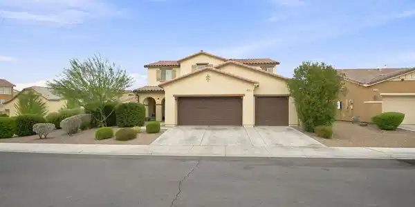 Image 2: A spacious driveway and multi-car garage anchor th