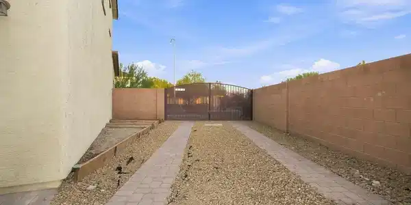 Image 4: A long paved driveway leads to a secure gated entr