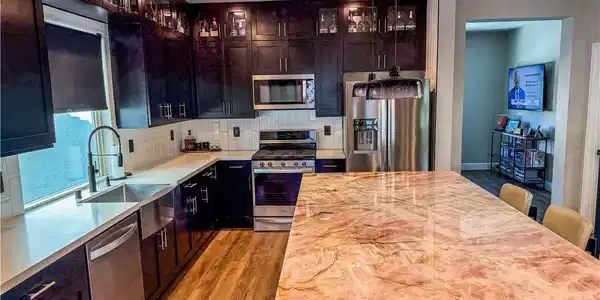 Image 2: Gleaming stone countertops and dark cabinetry defi