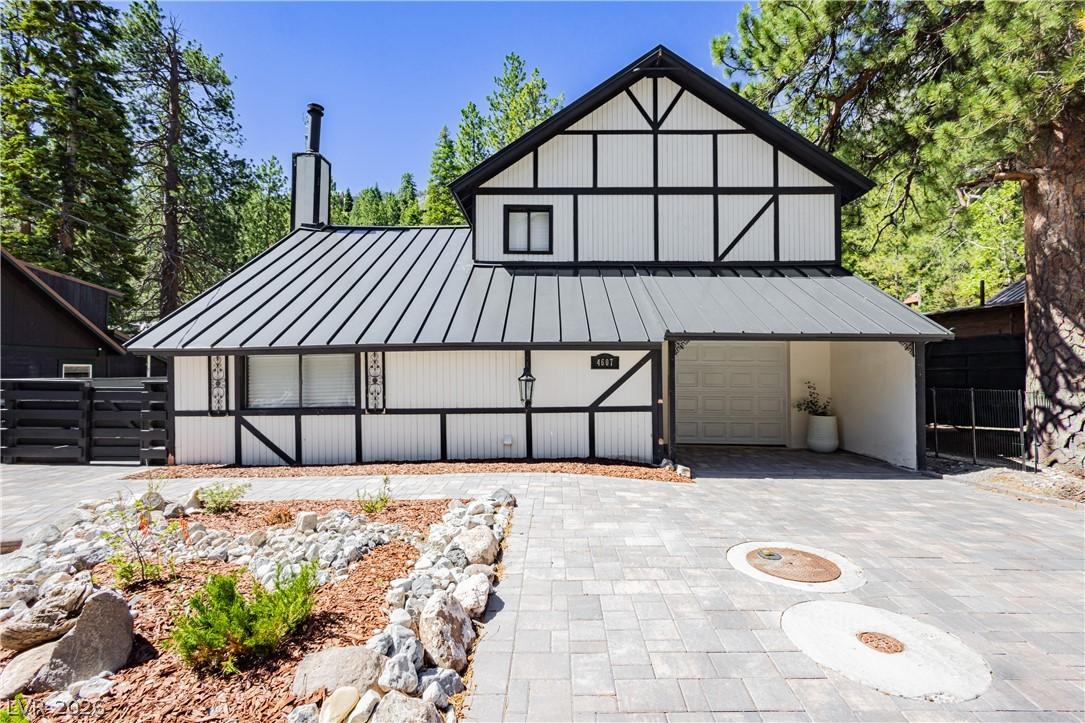 Image 2: A striking Tudor-style home with a modern metal ro