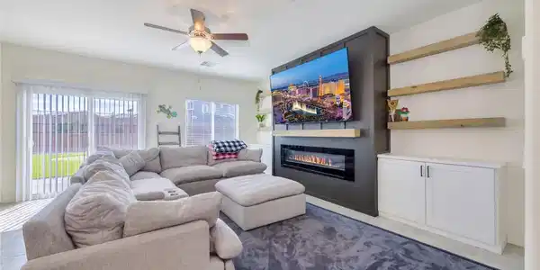 Image 3: A modern fireplace focal point anchors this bright
