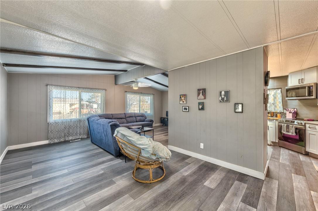Image 3: Living room with a textured ceiling, wood walls, a