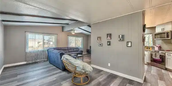 Image 3: Living room with a textured ceiling, wood walls, a