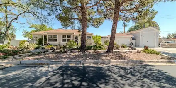 Image 2: A welcoming front yard with mature trees shades a