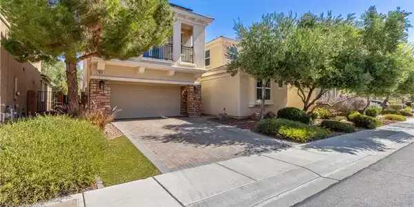 Image 2: A welcoming front exterior features a brick drivew