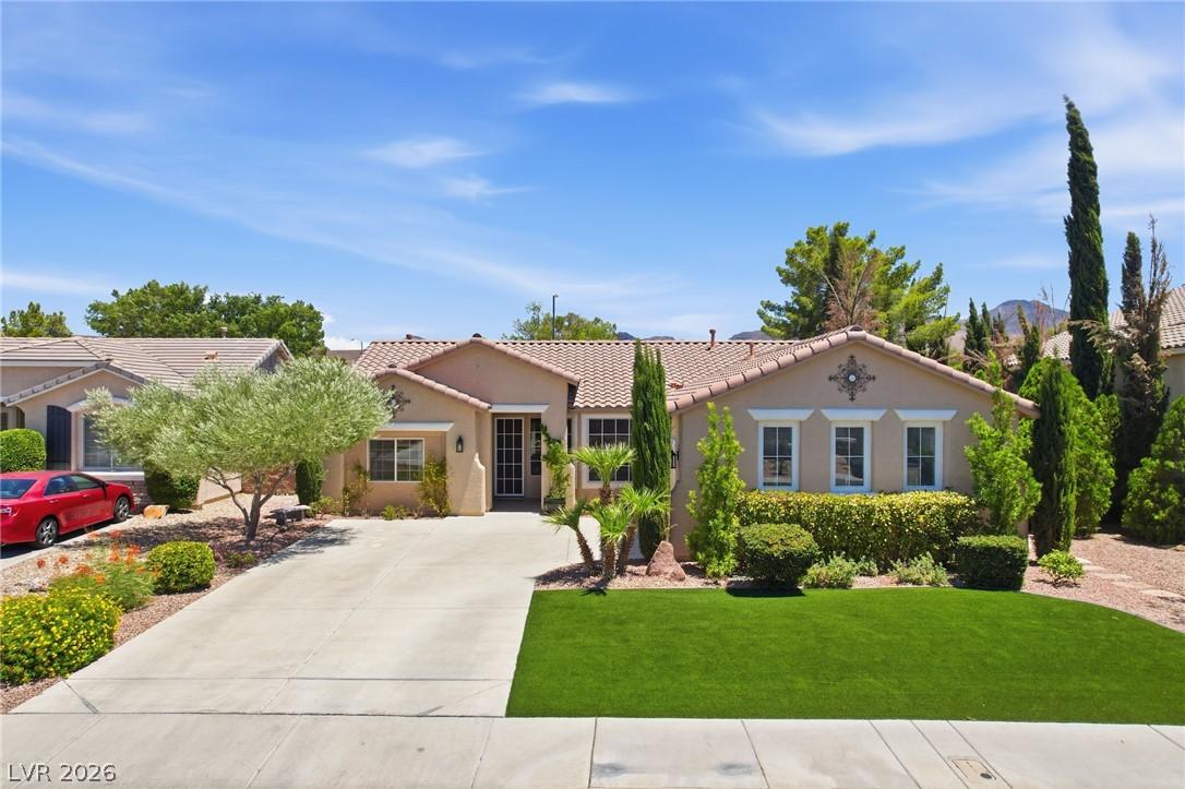 Image 1: A well-manicured front yard with a concrete drivew
