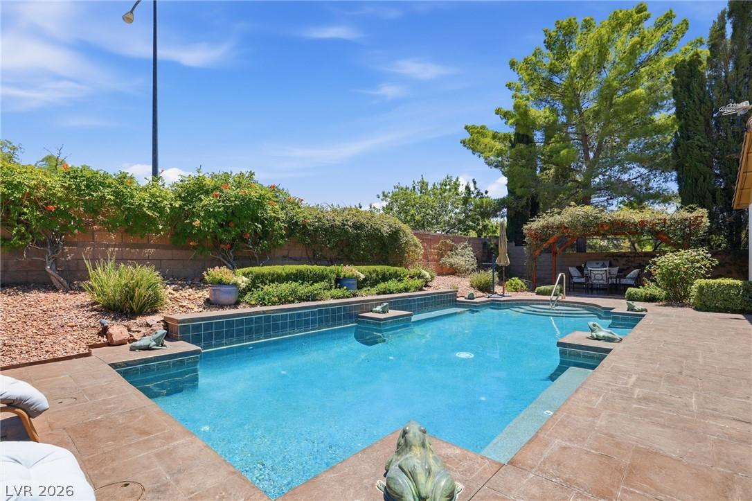 Image 3: An inviting backyard oasis offers a sparkling pool