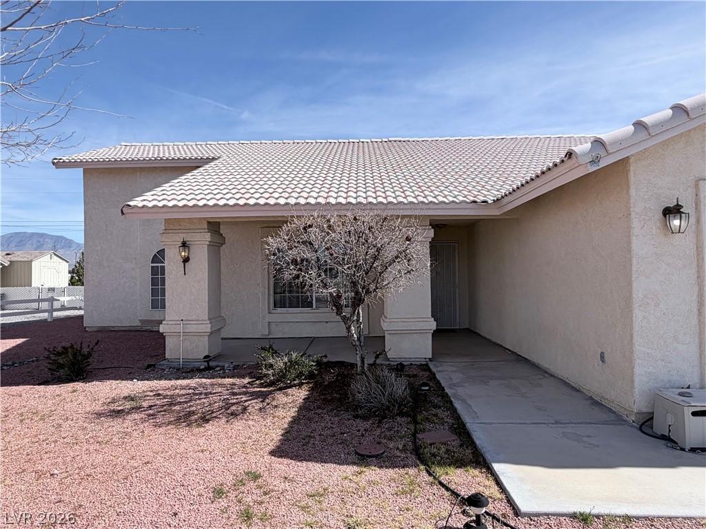 Image 3: View of exterior entry with stucco siding, a tiled
