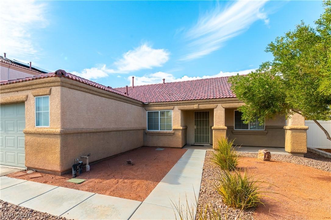 Image 2: A well-maintained stucco home with a tile roof and