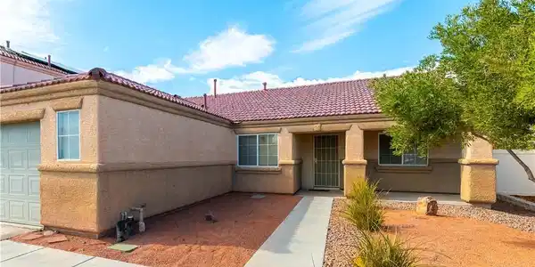 Image 2: A well-maintained stucco home with a tile roof and