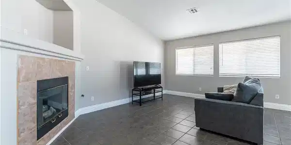 Image 4: A corner fireplace with a tiled surround anchors t