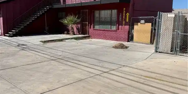 Image 2: An expansive concrete driveway leads alongside the