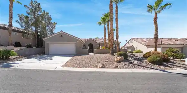 Image 3: Desert landscaping and towering palms frame this c