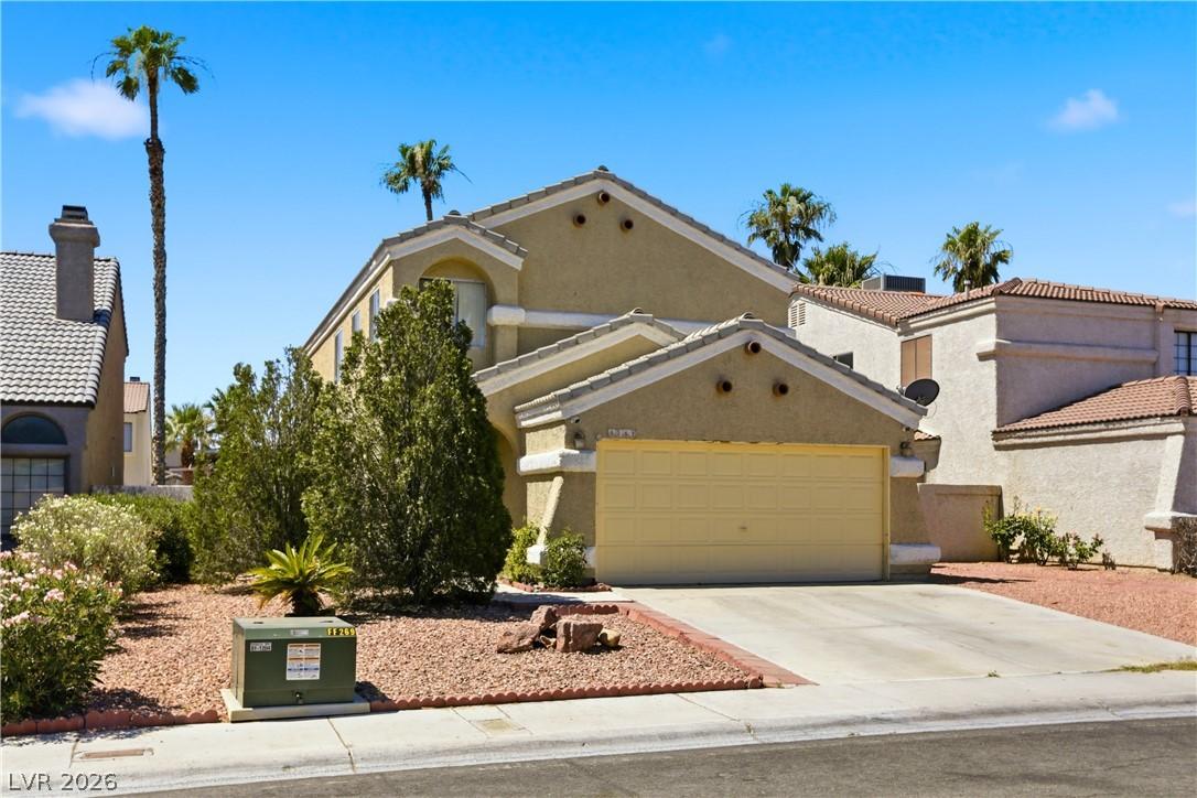 Image 3: A desert-friendly landscape greets this stucco res