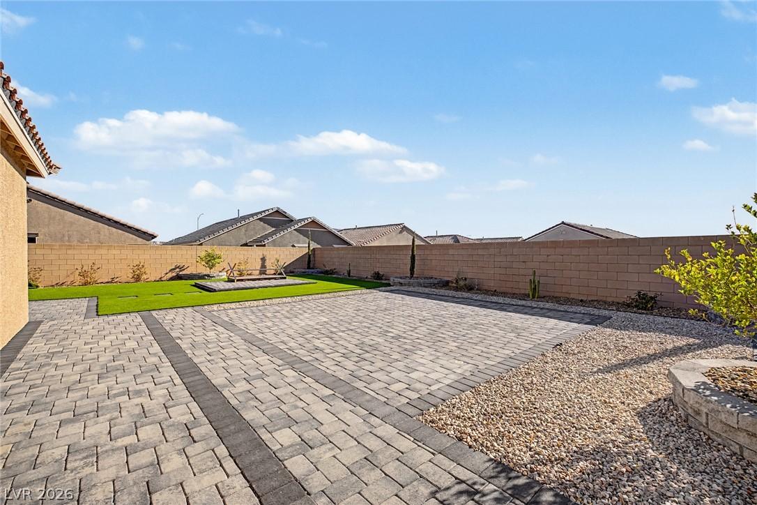 Image 2: A neatly paved patio extends to a vibrant green la
