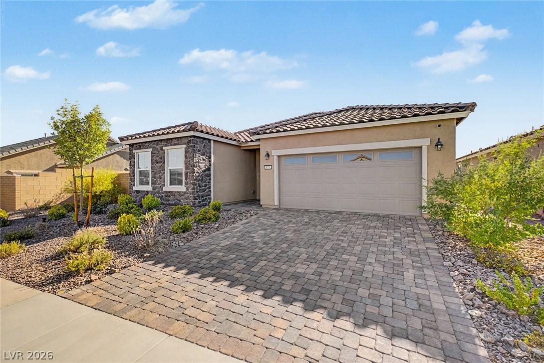 Image 4: A welcoming fa&ccedil;ade boasts a tile roof and a paver