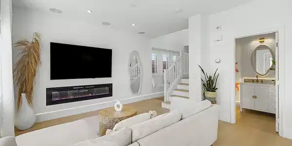 Image 4: A modern fireplace adds warmth to this open living