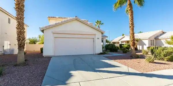 Image 2: A spacious concrete driveway leads to the attached