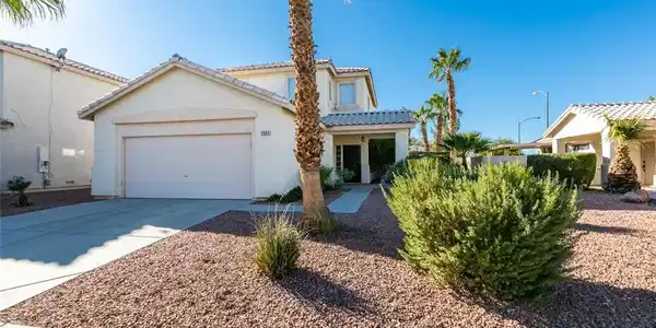 Image 3: Palm trees flank the entrance of this modern two-s