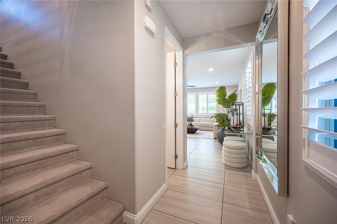 Image 4: A well-lit entryway features neutral floor tiles l