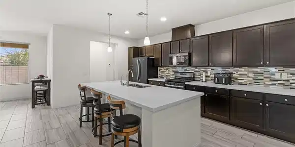 Image 2: Gleaming stone countertops and dark cabinetry crea