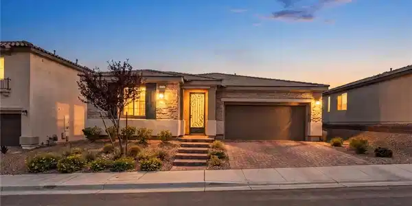 Image 3: A stone-accented facade and paver driveway create