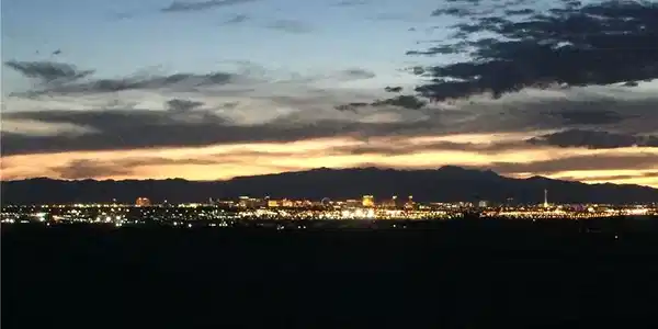 Image 4: Glittering city lights frame the mountain horizon