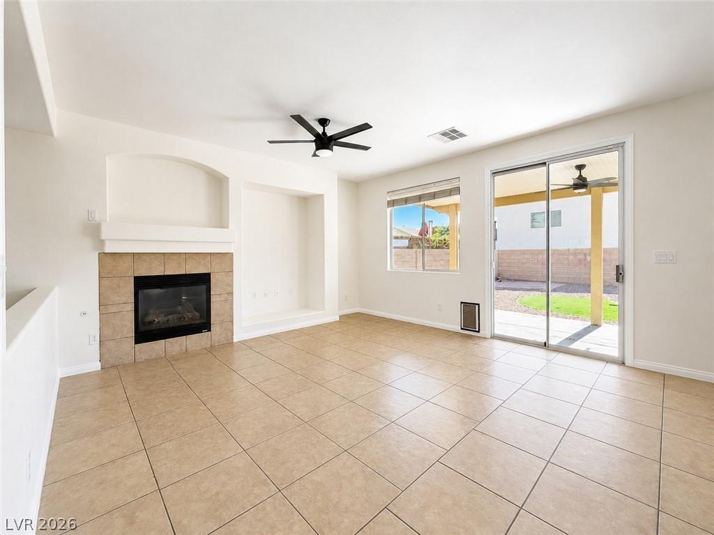 Image 4: A spacious living room features a tiled fireplace,