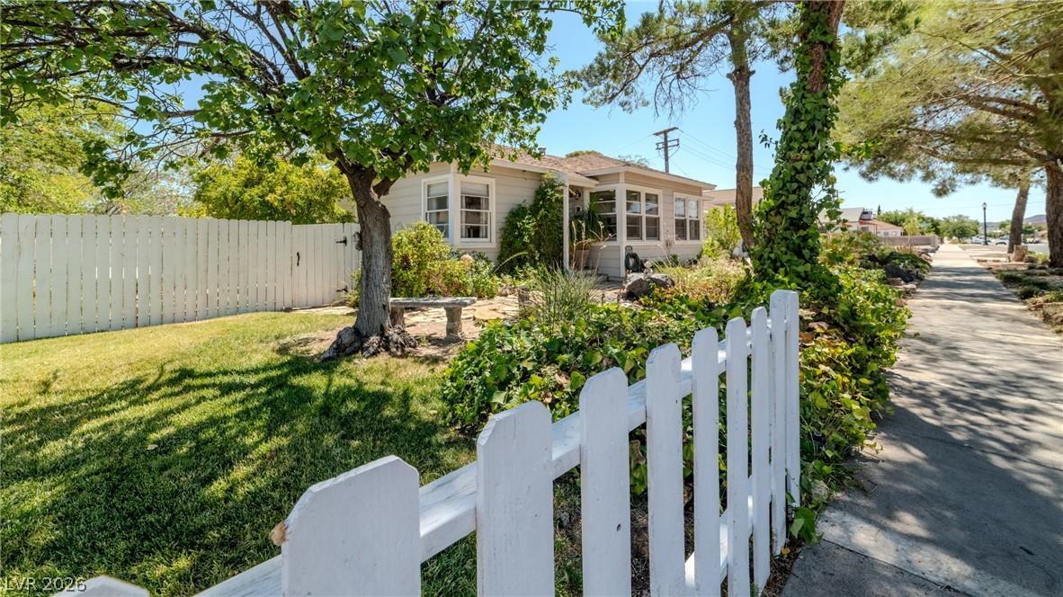 Image 3: A classic picket fence and lush landscaping welcom