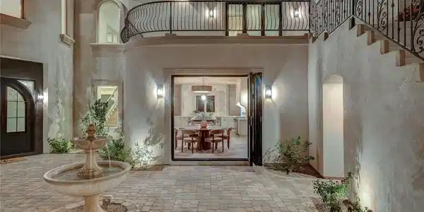 Image 4: An elegant paved courtyard features a stone founta