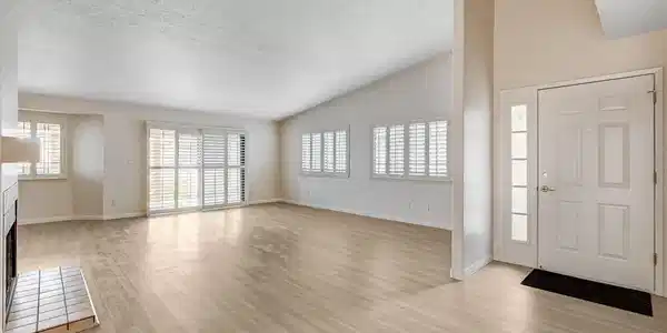 Image 3: A spacious living area with vaulted ceilings and a