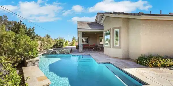 Image 2: An inviting backyard oasis offers a sparkling pool