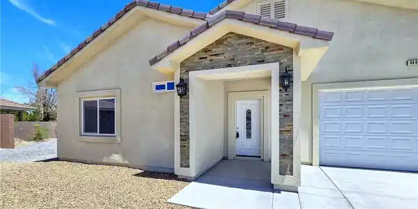 Image 4: A welcoming entry, with a stone-clad porch and att